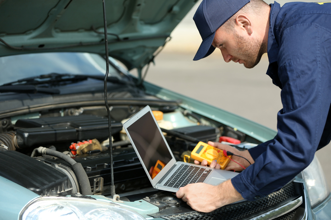 Mechanic Using Laptop to Repair Car